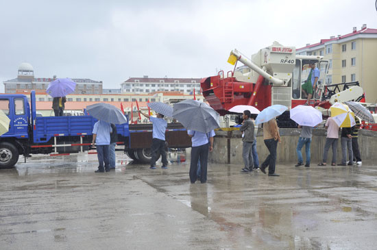 冒雨將雷沃谷神水稻收割機(jī)拉回家